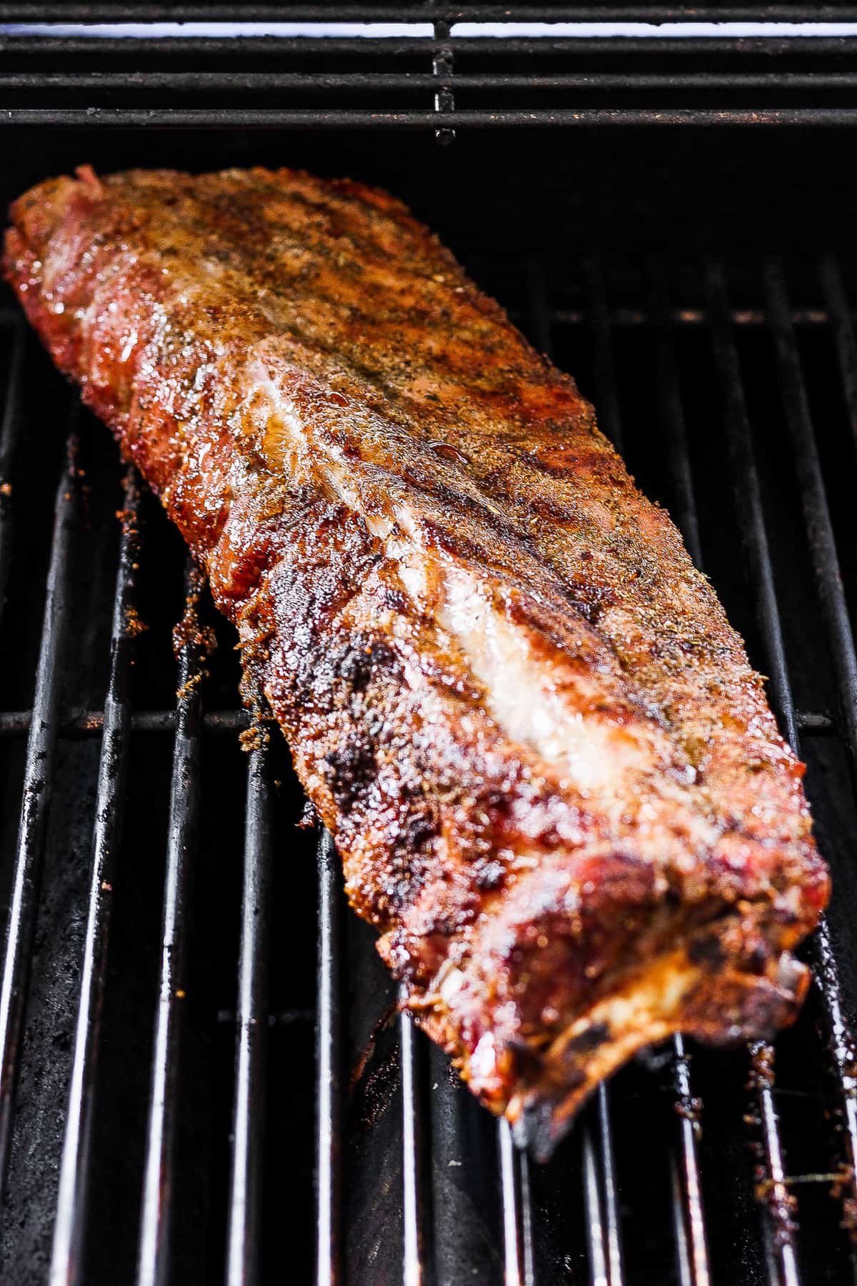 Rack of ribs cooking on the grill.