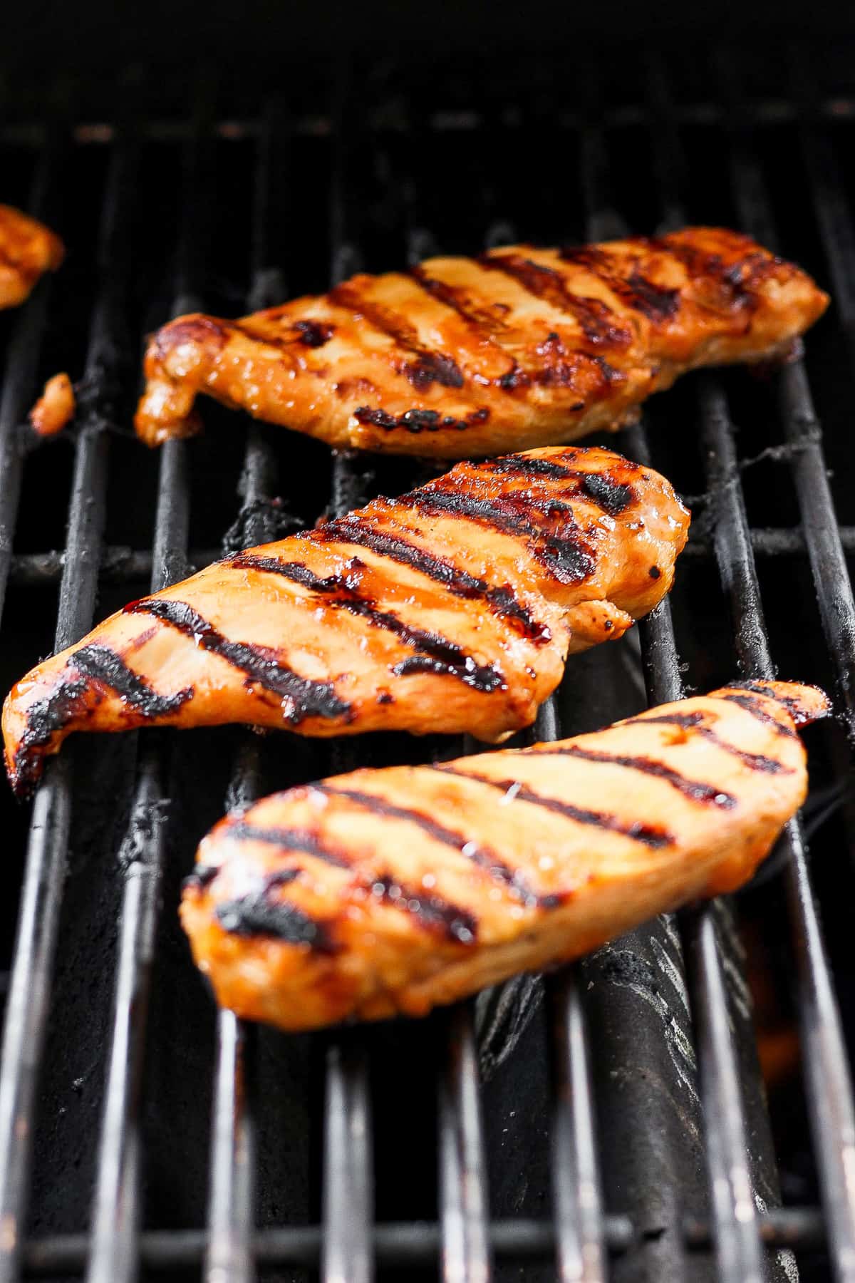 a close up of a grill with chicken on it.