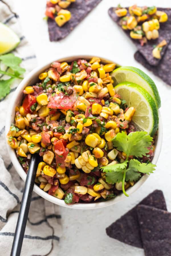 mexican corn salad in a bowl with tortilla chips.