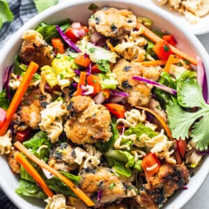 Asian chicken noodle salad in a white bowl.