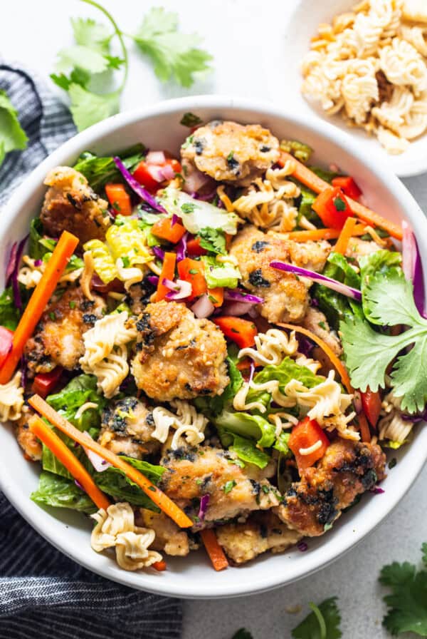 Asian chicken noodle salad in a white bowl.