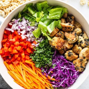 A white bowl filled with asian chicken salad.