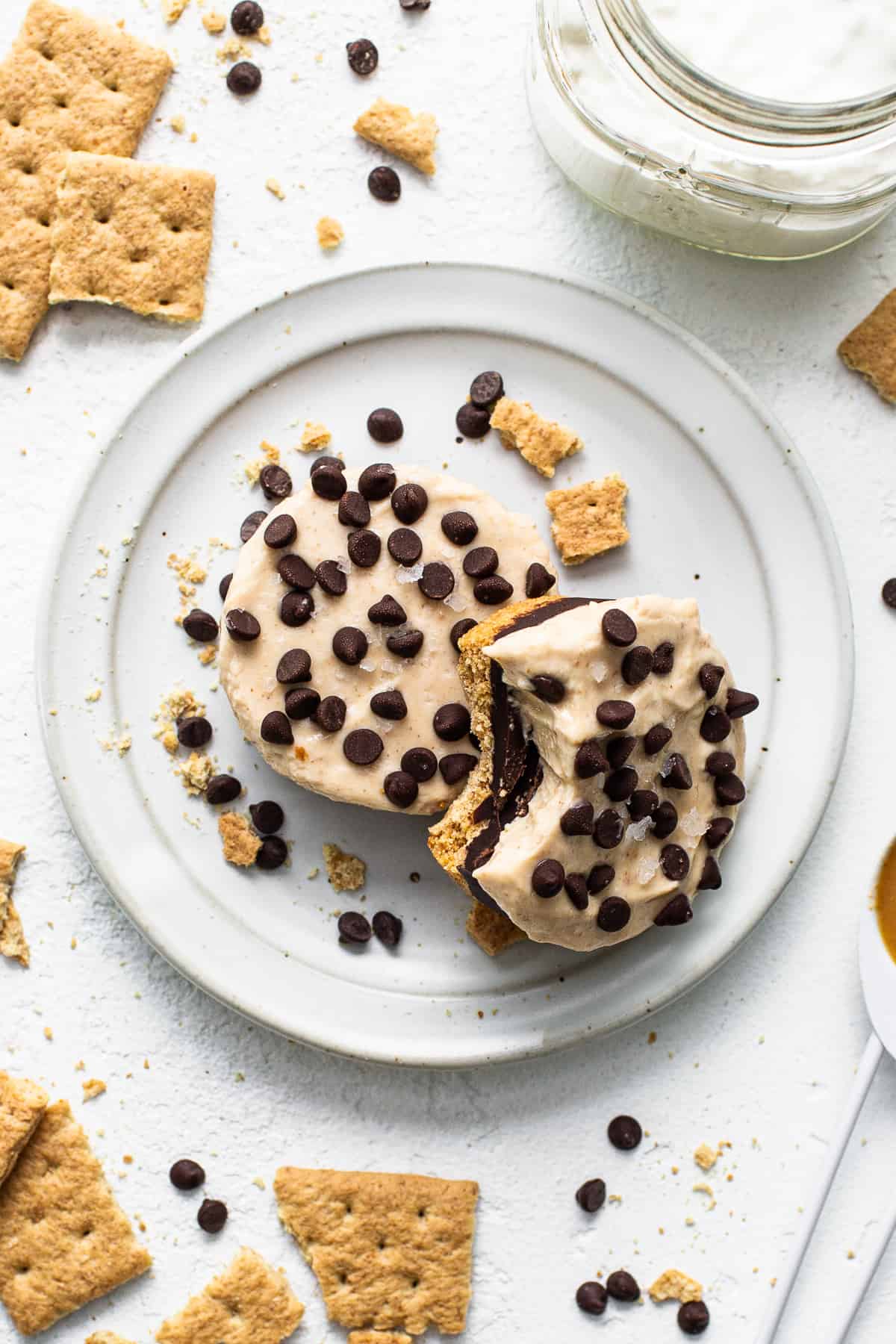 Peanut butter chocolate cheesecake cups on a plate with a bite taken out of them.