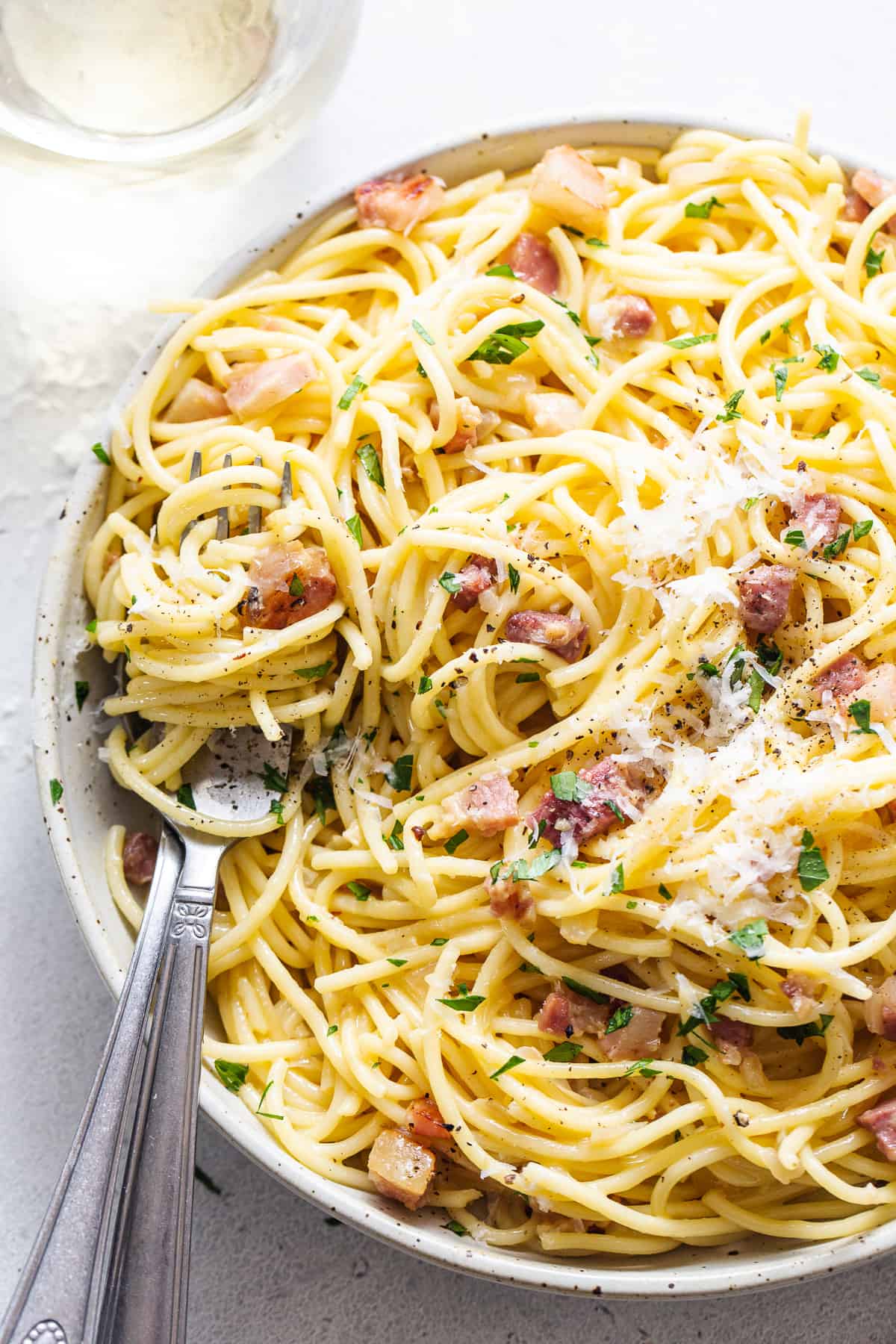 A plate of spaghetti with bacon and parmesan.