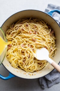 A pot of spaghetti with bacon and orange juice.