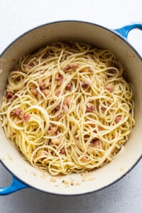 A pan full of spaghetti with bacon in it.
