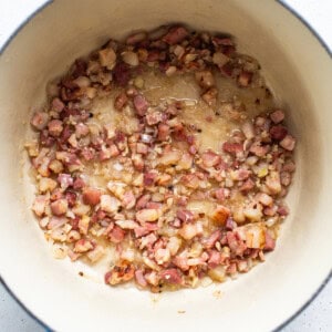 Bacon in a blue pot on a white surface.