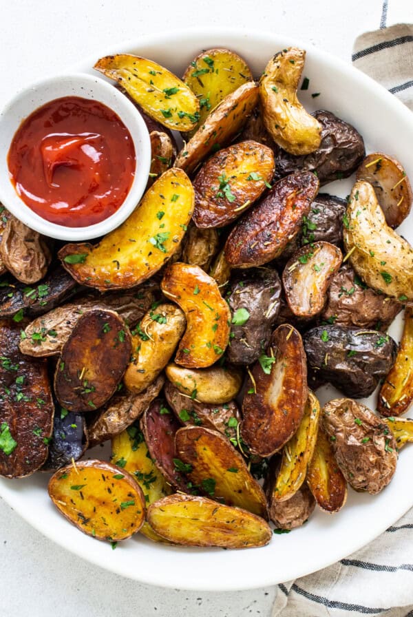 bowl of roasted potatoes and ketchup.