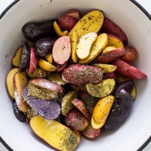 seasoning potatoes in bowl.