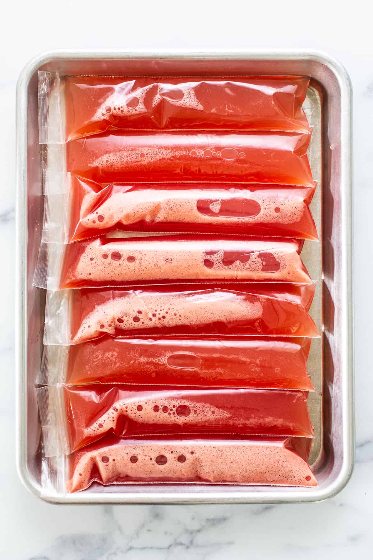 watermelon freeze pops on baking sheet.