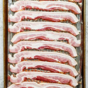 sliced bacon on a baking sheet.