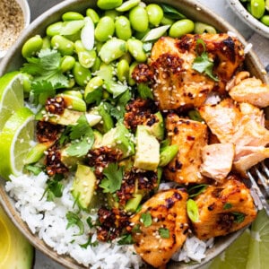 a bowl filled with chicken, rice and vegetables.