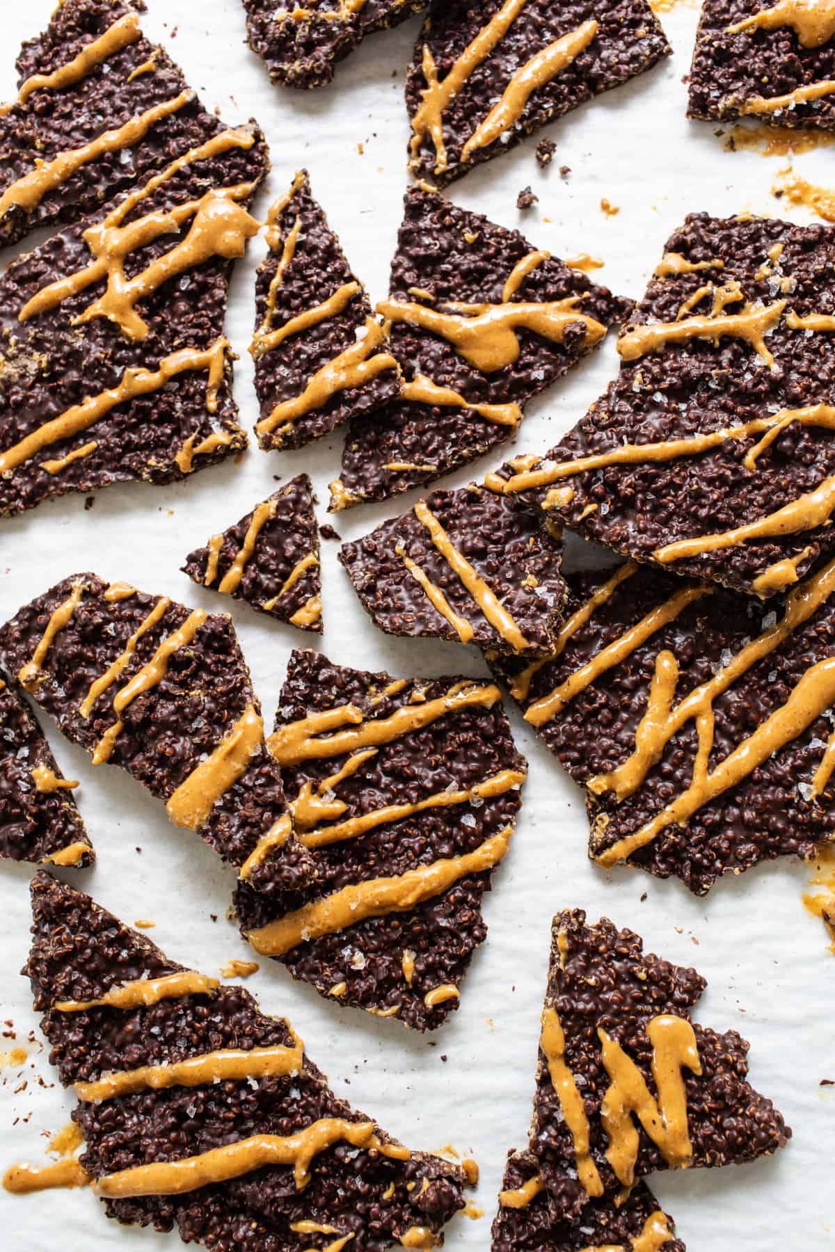 a pile of cookies with peanut butter drizzled on them.