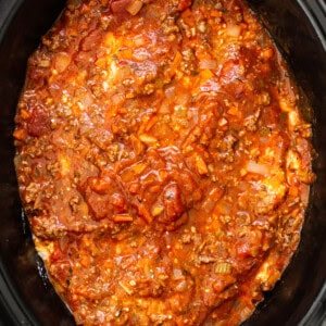 a crock pot filled with chili and meat.