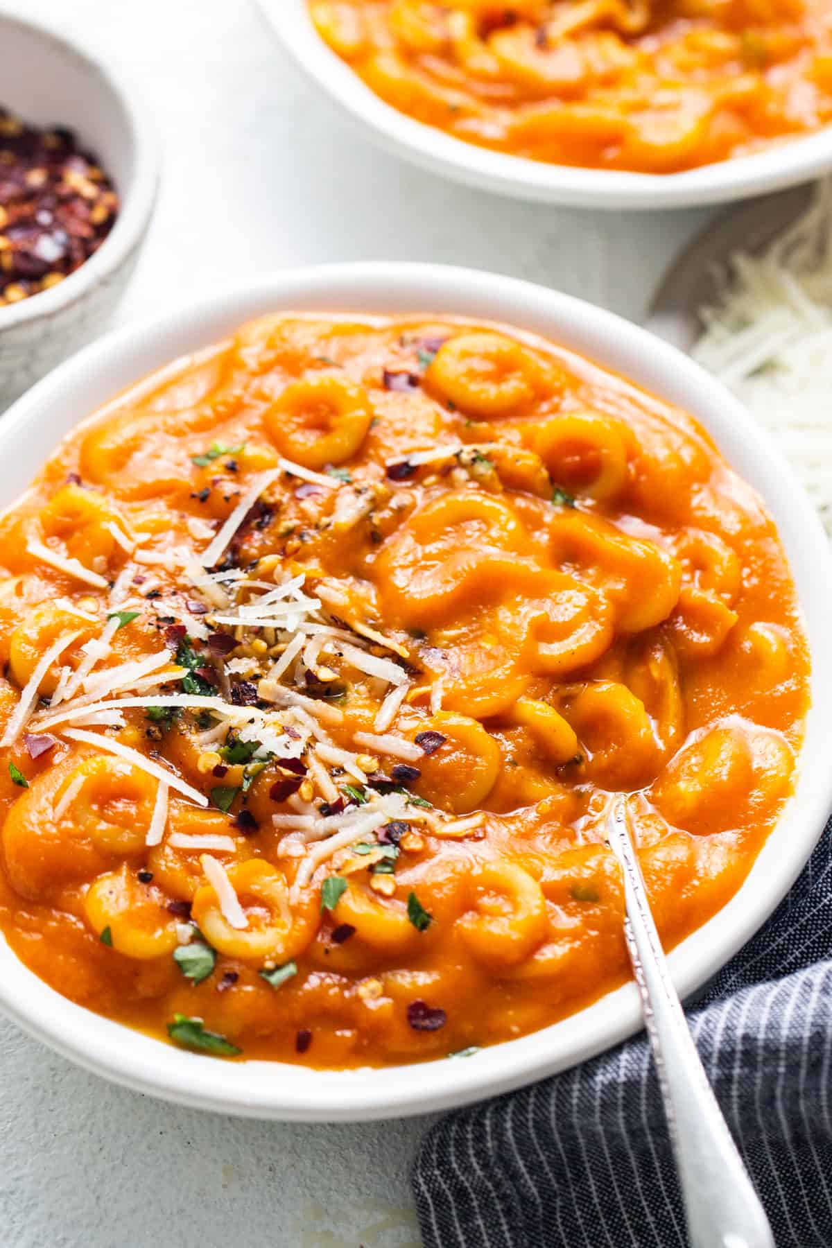 a bowl of macaroni and cheese soup with a spoon.