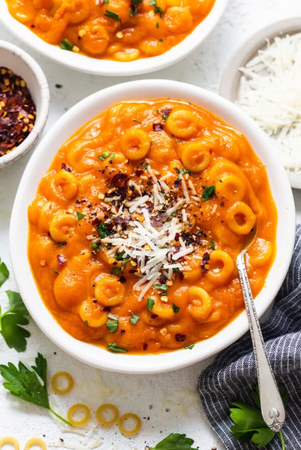 two bowls of macaroni and cheese soup on a table.