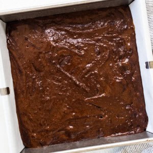 a pan of chocolate cake next to a bowl of chocolate chips.