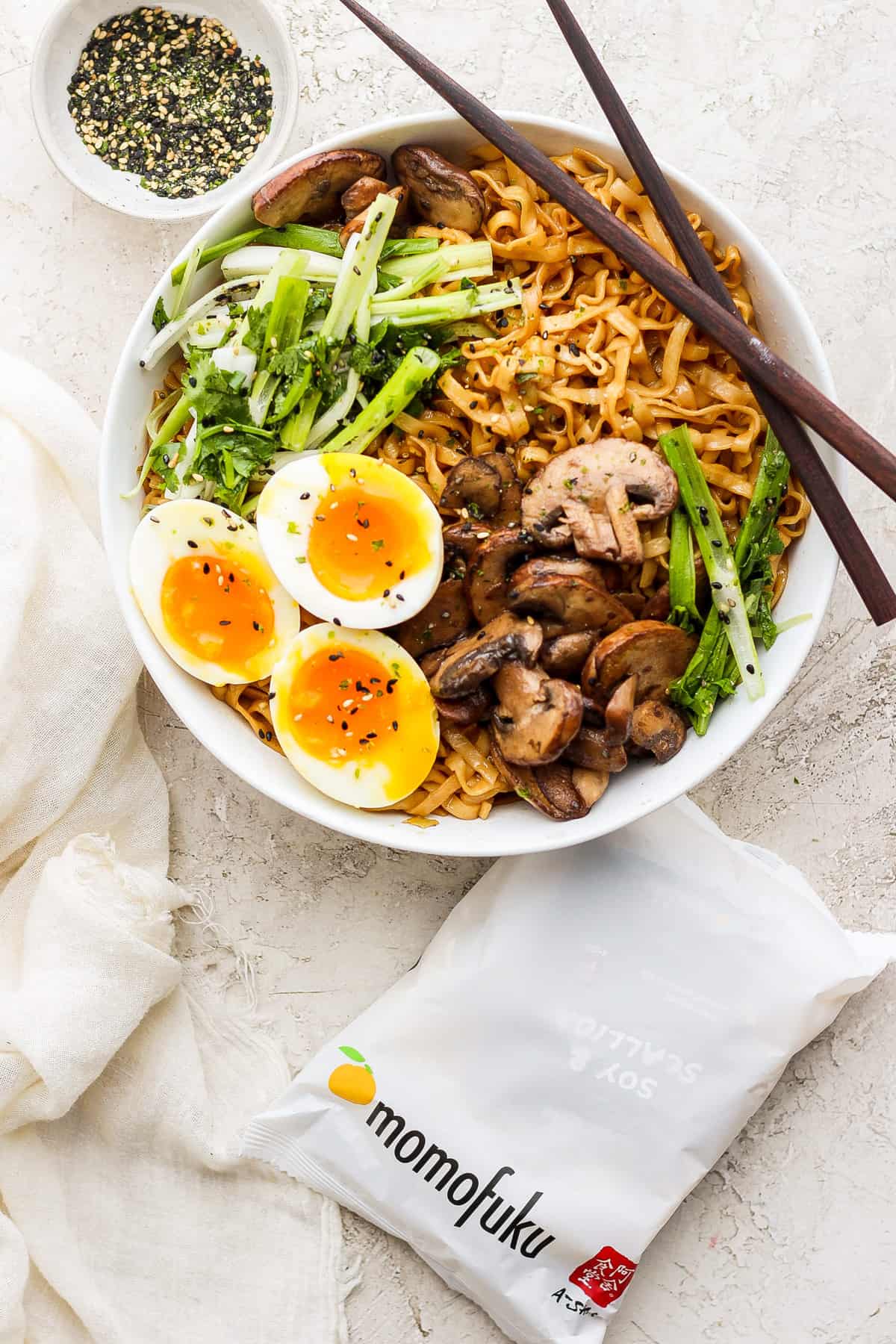 a bowl of ramen with mushrooms, eggs and chopsticks.