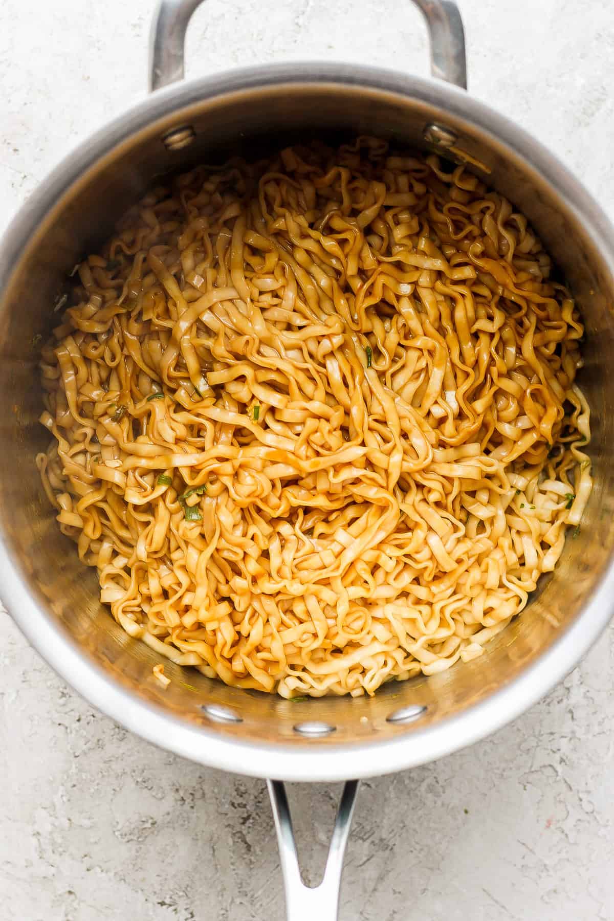 a pan with noodles in it on a white surface.