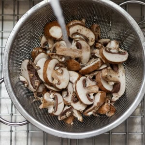 mushrooms in a strainer on a cooling rack.