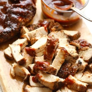 a bbq chicken dish served on a wooden cutting board.