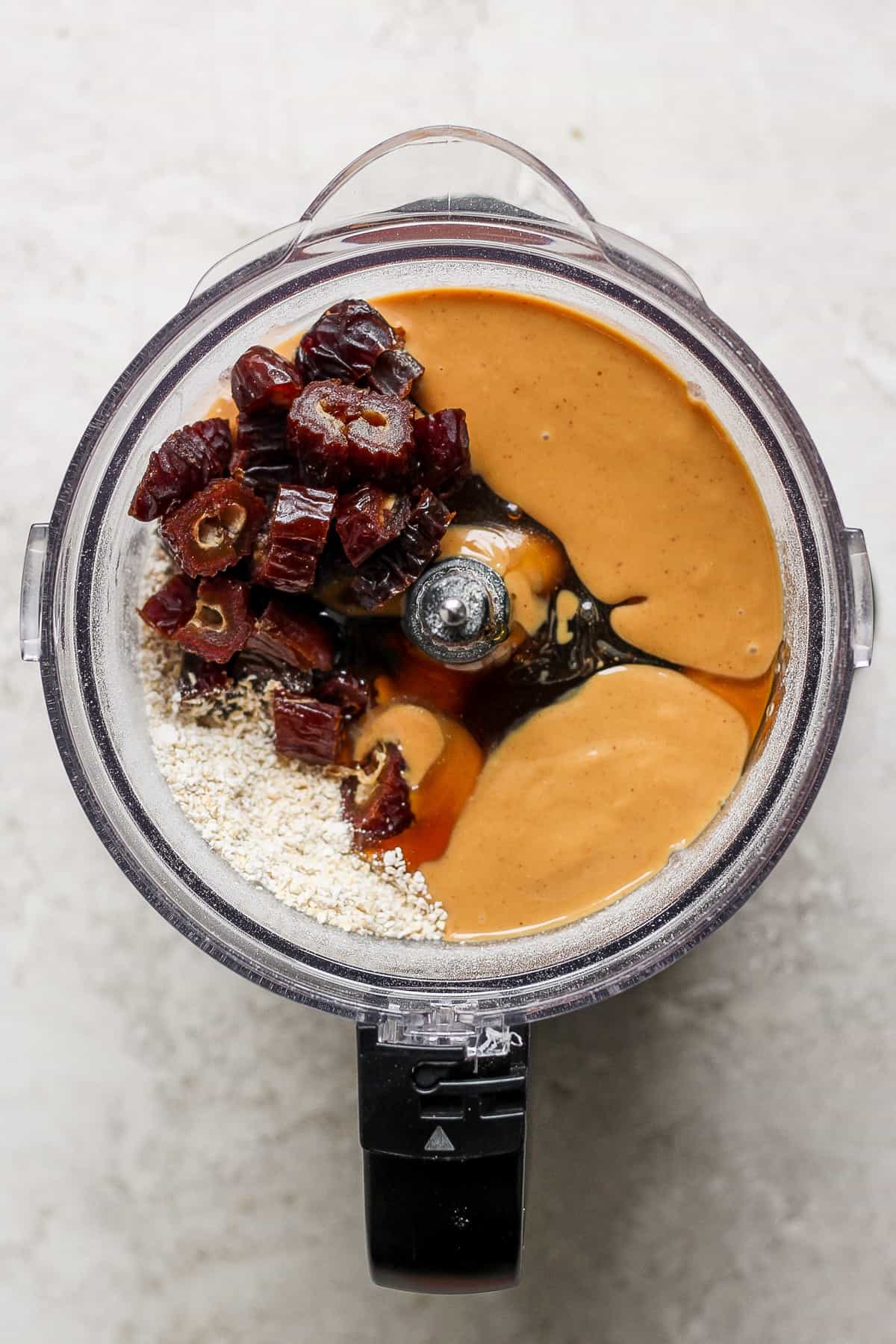 a food processor filled with ingredients for a peanut butter granola.