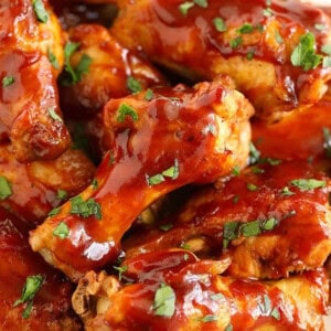 Crock pot chicken wings smothered in BBQ sauce neatly arranged on a plate.