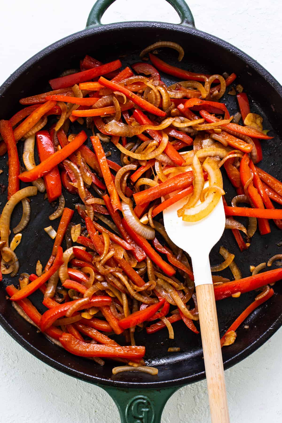 A skillet filled with red peppers and onions.