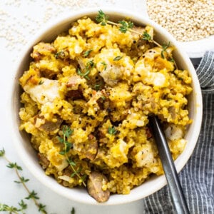 A bowl of rice with meat and thyme.