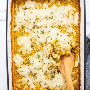 A casserole dish with a wooden spoon in it.