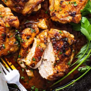 Chicken breasts in a skillet with parsley and herbs.