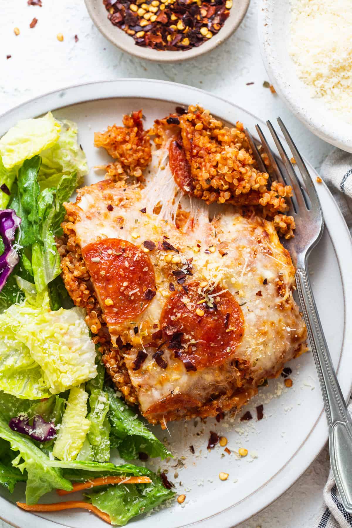 A plate with a pizza and salad on it.