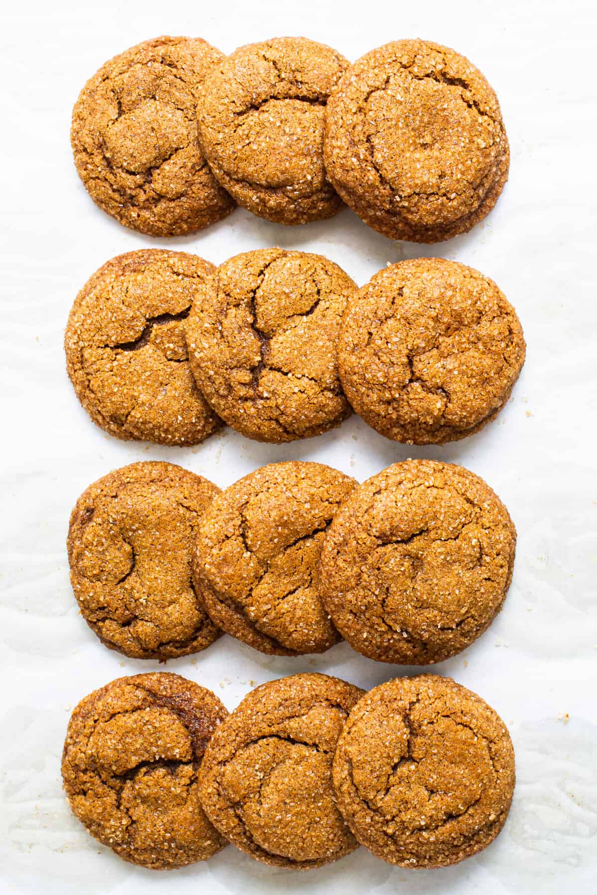 A row of ginger cookies on a white surface.