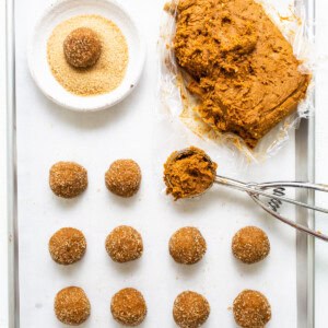 A baking sheet with a tray of doughnuts and a spatula.