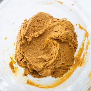 A bowl of pumpkin batter in a glass bowl.