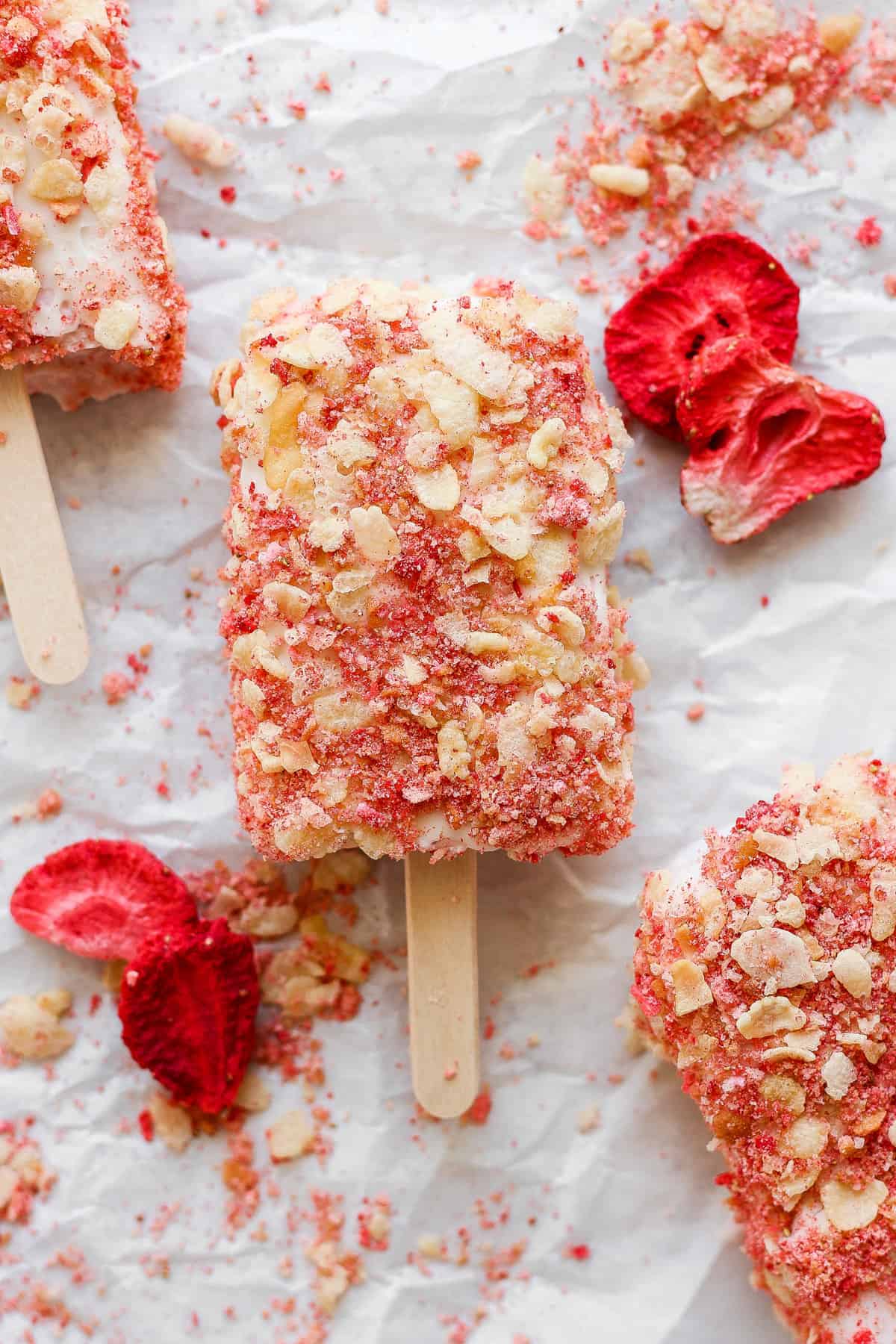 Strawberry popsicles on a sheet of paper.