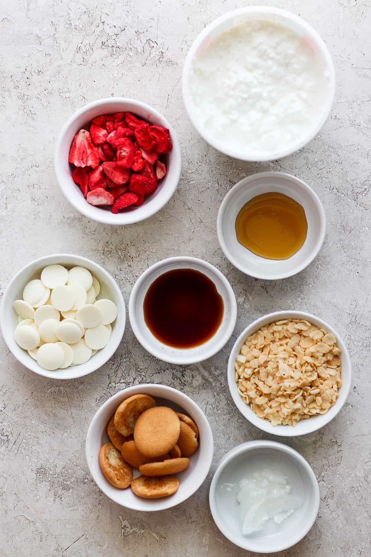 Various bowls of ingredients for a strawberry milkshake.