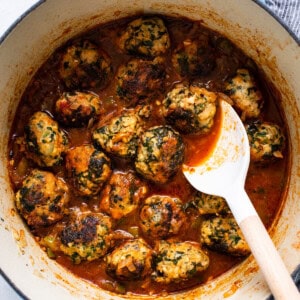 Meatballs in tomato sauce with a spoon.