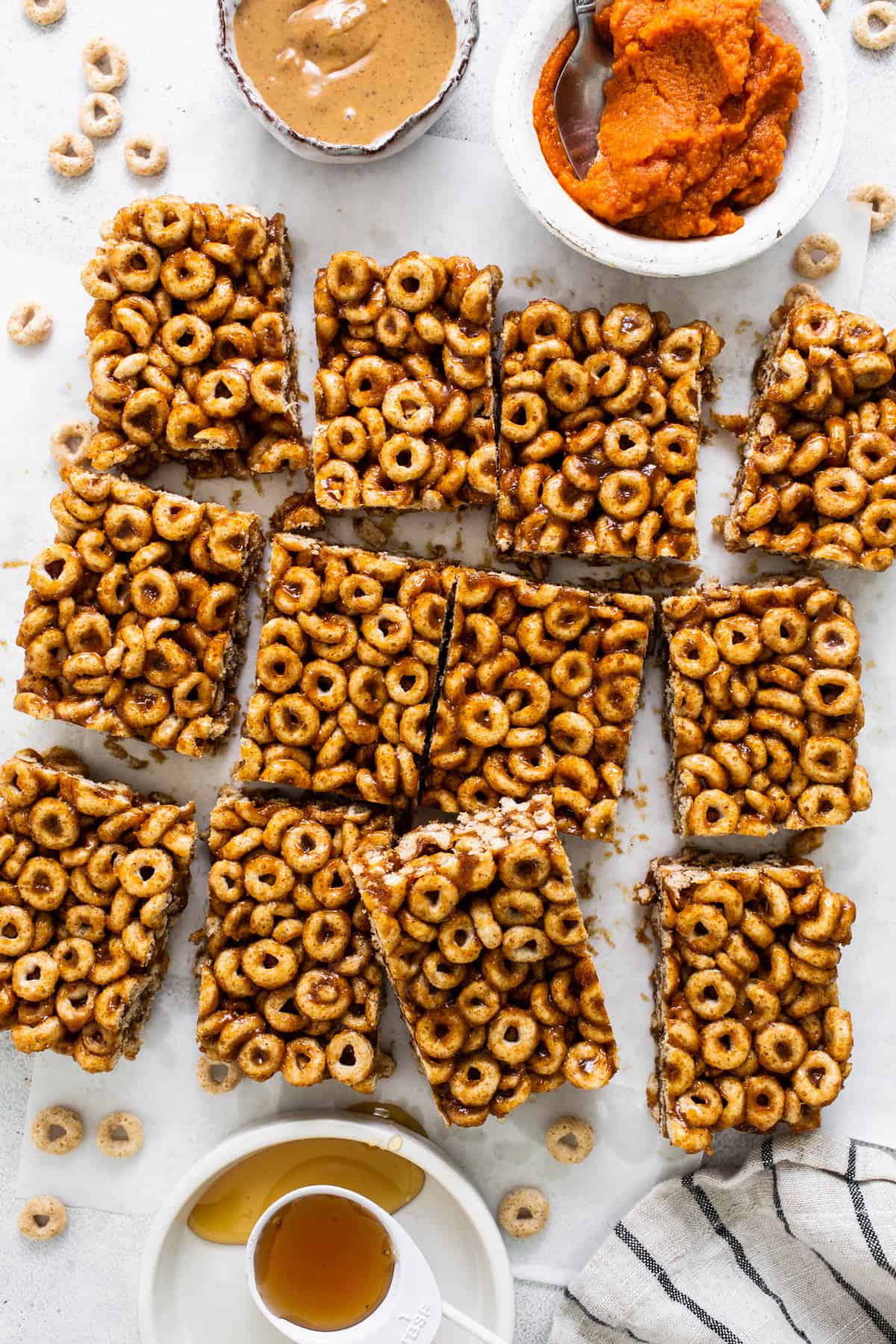 A plate of granola bars with a bowl of peanut butter.