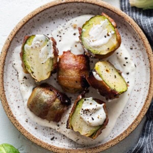 Brussels sprouts with bacon and sour cream on a plate.