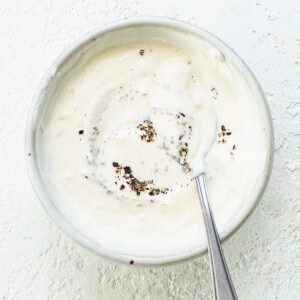 A bowl of yogurt with a spoon in it.