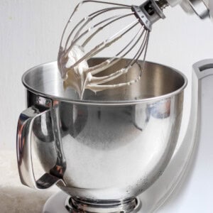 A white mixer with a whisk in it.