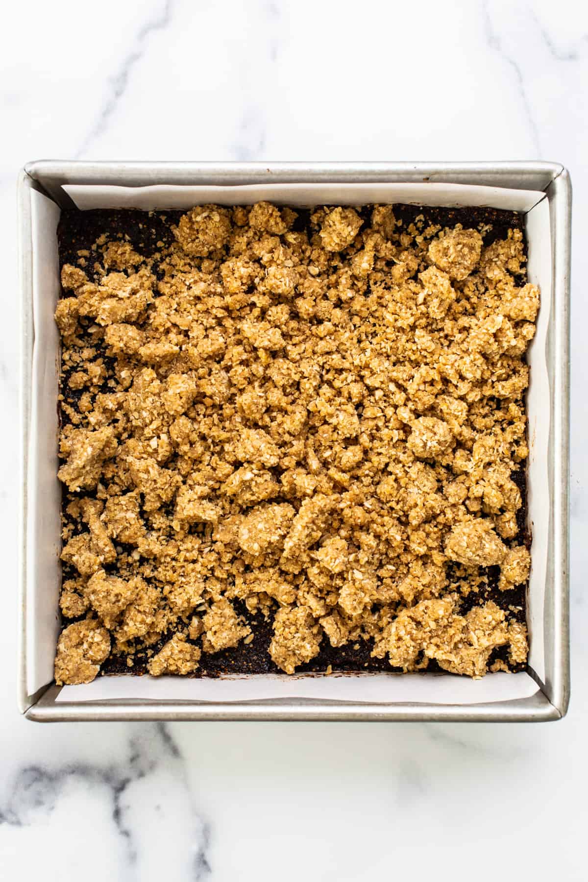 A baking pan with a layer of granola in it.