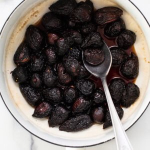 Dried figs in a pan with a spoon.