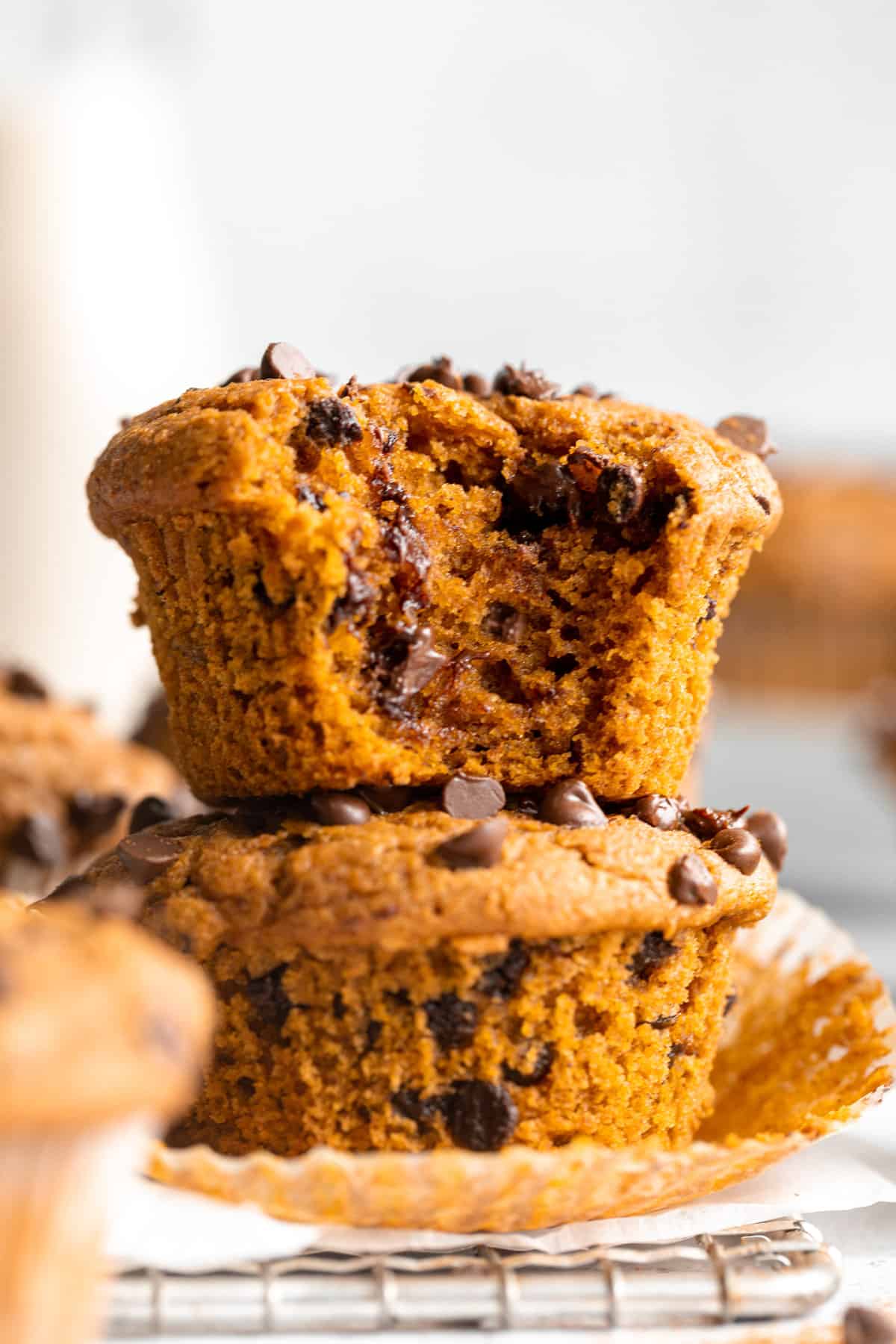 Pumpkin chocolate chip muffins stacked on top of each other.