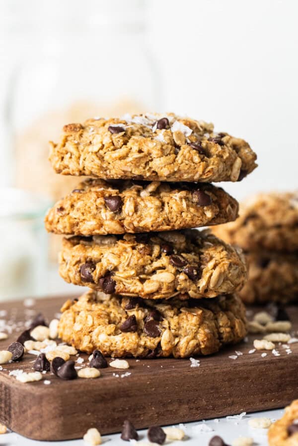 A stack of oatmeal cookies on a cutting board.