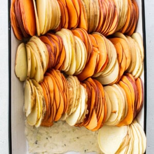 Sliced sweet potatoes in a baking dish.