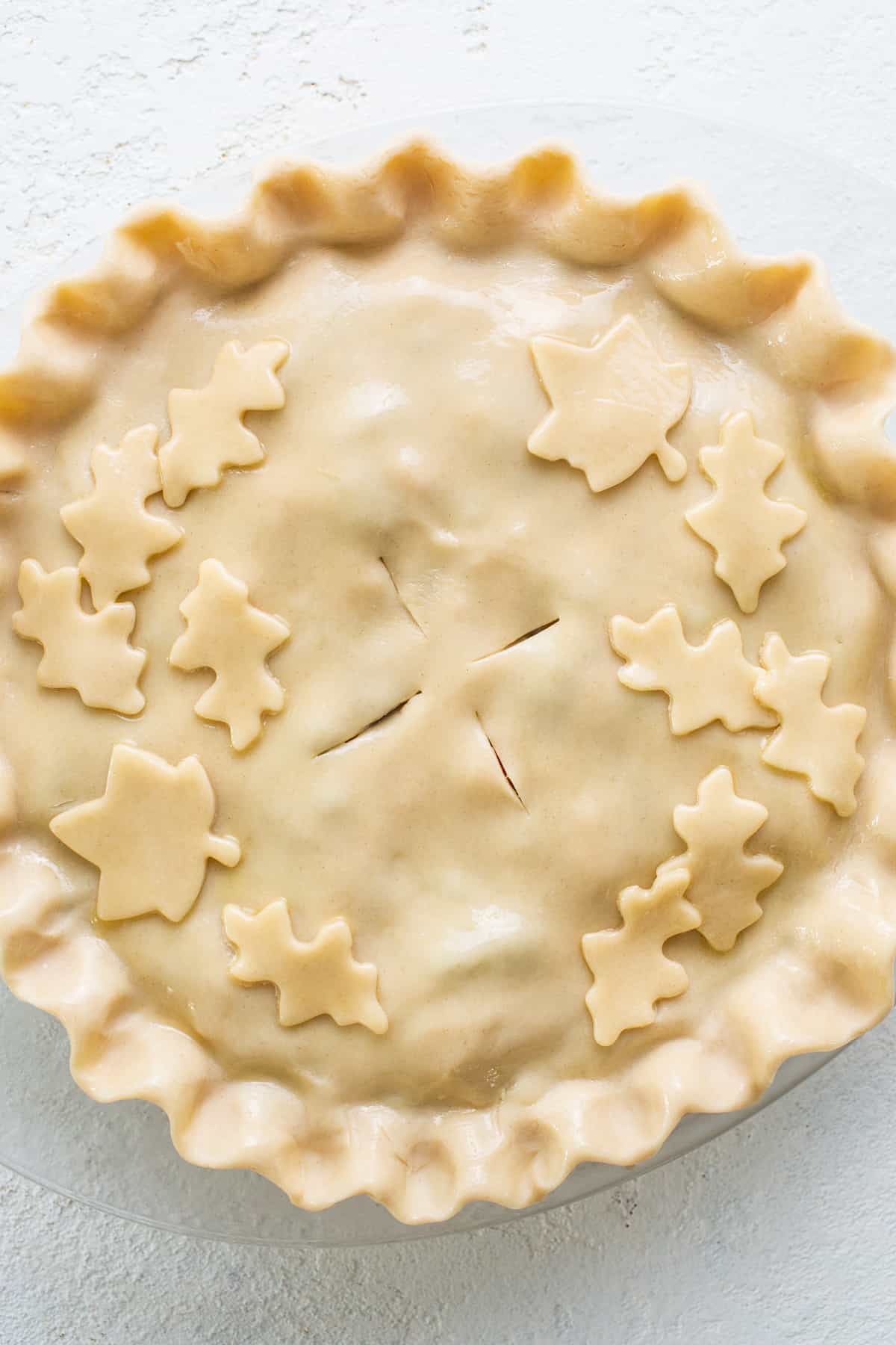 A pie with leaves on top of it.