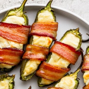 Bacon wrapped jalapenos on a plate.