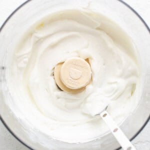 A bowl of whipped cream with a banana slice in it.